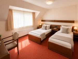 a hotel room with two beds and a window at Hotel Esingerhof by Alesta in Tornesch