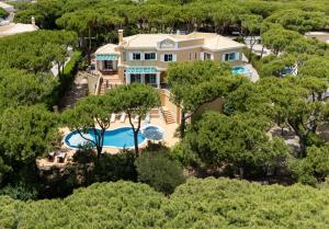 an aerial view of a house with a swimming pool and trees at Villa Praia Verde - Beach & Nature in Praia Verde