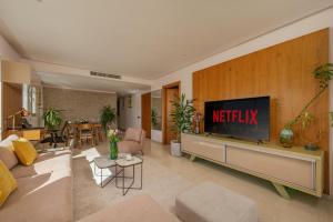 a living room with a television on a wall at anfa Louise in Casablanca