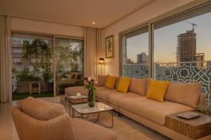 a living room with a couch and chairs and windows at anfa Louise in Casablanca