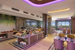 a restaurant with tables and chairs in a room at Vivanta Gurugram Sector 95A in Gurgaon