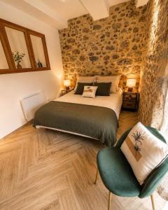 a bedroom with a large bed and a chair at A La Voile Blanche in Bouzigues