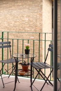 a glass table and two chairs on a balcony at BluesHouse La Fenice in Bologna