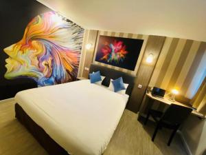 a bedroom with a bed with a painting on the wall at Urban House in Roubaix