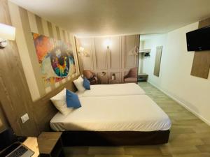 a hotel room with two beds and a laptop at Urban House in Roubaix +5 photos