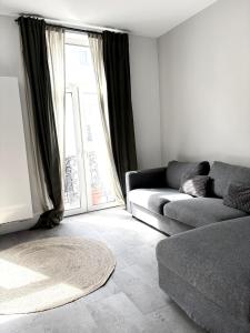 a living room with a couch and a large window at Brussels Loft in Brussels