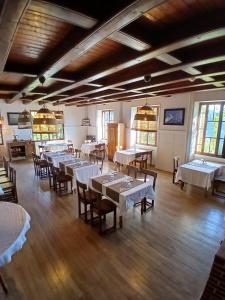 a dining room with tables and chairs and windows at Auberge du Belvédère in Séez