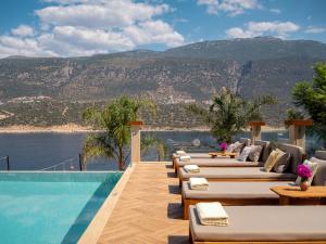 a hotel with a pool and a view of the mountains at Suna Sun Hotel - Adult Only in Kaş