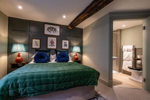 a bedroom with a green bed and a bathroom at The Bell & Stuart House in Stow on the Wold