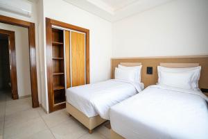 a bedroom with two beds and a closet at Zephyr Saidia in Saïdia