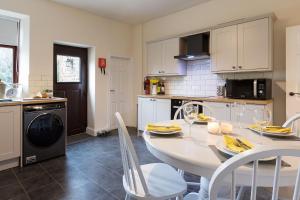a kitchen with a white table and chairs in a kitchen at Vera's cottage in Edale