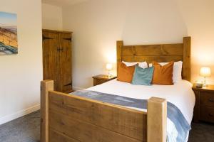 a bedroom with a large wooden bed and two lamps at Vera's cottage in Edale