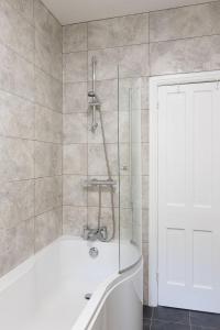 a bathroom with a tub and a shower with a glass door at Vera's cottage in Edale +14 photos