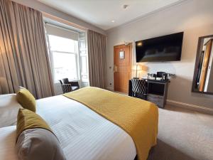 a hotel room with a large bed and a flat screen tv at The Angus Hotel & Spa by Compass Hospitality in Blairgowrie