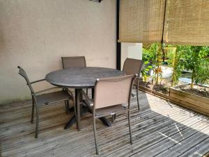 a table and chairs on a deck with a patio at Gîte la Bourgeoise in Bléré