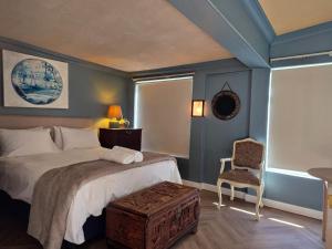 a bedroom with a large bed and a chair at Paul René Manor House in Robertson