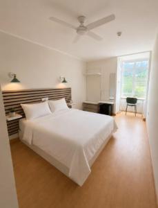 a white bedroom with a large white bed and a window at Hotel Peña Pintada by Vivere Stays in Lañada