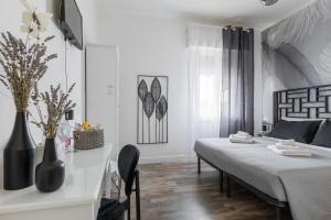 a white room with a bed and a table with chairs at BluesHouse La Fenice in Bologna