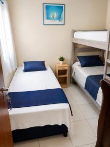 two beds in a room with two bunk beds at Balcony house in Campo Grande