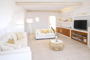 a living room with a white couch and a television at LUX-Porto Cervo Center Sea View Apartment in Porto Cervo