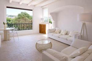 a living room with white furniture and a large window at LUX-Porto Cervo Center Sea View Apartment in Porto Cervo