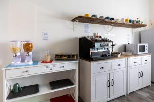 a kitchen with white cabinets and a counter with a microwave at BluesHouse La Fenice in Bologna +52 photos