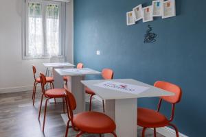 a room with four tables and orange chairs at BluesHouse La Fenice in Bologna