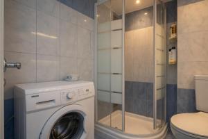 a bathroom with a washing machine and a toilet at Voula Asklipeio Residence Supreme in Athens