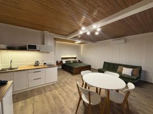 a kitchen and living room with a table and a couch at Pletey house in Verkhovyna
