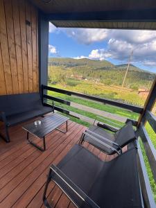 a balcony with a table and chairs and a view at Pletey house in Verkhovyna +11 photos