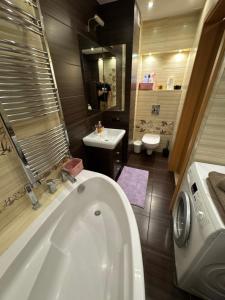 a bathroom with a white tub and a sink at Apartament Górnicza in Gdynia +6 photos