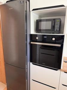 a kitchen with a microwave and a refrigerator at Apartament Górnicza in Gdynia