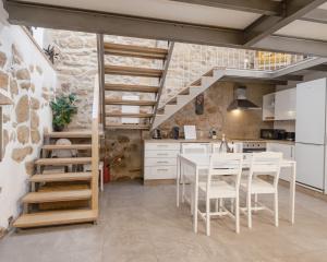 a kitchen with a table and chairs and a staircase at Casa da Caleira in Fonte Arcada