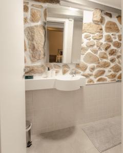 a bathroom with a sink and a stone wall at Casa da Caleira in Fonte Arcada +29 photos