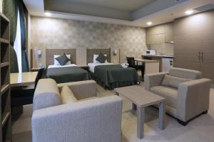a room with two beds and a couch and a kitchen at Sen Otel in Sakarya