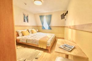 a small bedroom with a bed and a window at Castle Park Suites in Hermina-major