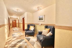 a living room with two chairs and a hallway at Castle Park Suites in Hermina-major