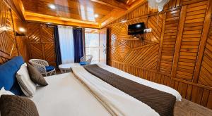 a bedroom with a bed in a room with wooden walls at Nainital Hill View Boho in Nainital +30 photos
