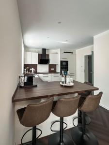 a kitchen with a large wooden counter with three bar stools at LUMEA Devin in Stralsund
