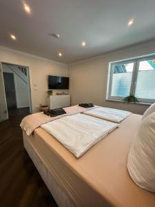 a large bed in a bedroom with a large window at LUMEA Devin in Stralsund