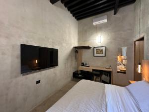a bedroom with a bed and a desk with a television at Casa 1800 Oaxaca Boutique Hotel in Oaxaca City