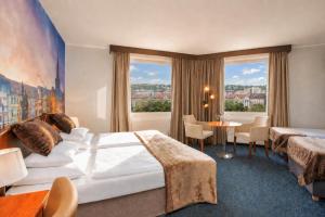 a hotel room with a bed and a table at Plaza Boutique Hotel - Czech Leading Hotels in Prague +18 photos