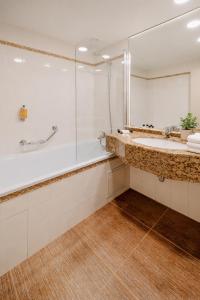 a bathroom with a tub and a sink and a mirror at Plaza Boutique Hotel - Czech Leading Hotels in Prague