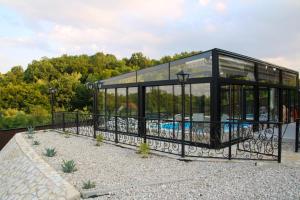 a glass building with a fence around it at Koliba & SPA SlaDjo in Brčko