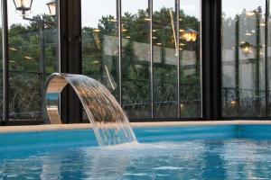 a water fountain in a pool in a building at Koliba & SPA SlaDjo in Brčko +21 photos
