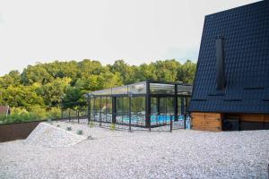 a house with a swimming pool in a glass house at Koliba & SPA SlaDjo in Brčko