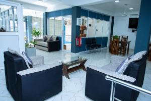 a living room with blue walls and chairs and a table at JAI REST In in Jaffna