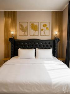 a bedroom with a large white bed with two pillows at Bali Queen Cottage in Pabean Buleleng