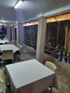 a dining room with white tables and chairs at Laletsa Lodge in Durban