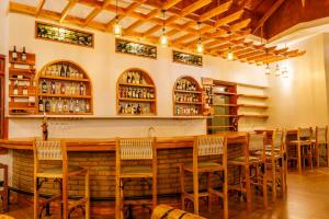 a restaurant with a bar with chairs and shelves at Chui hidden Lodge Karatu in Karatu